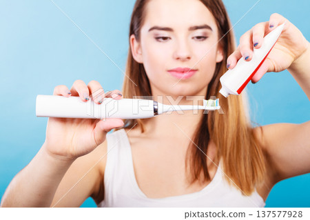 Woman applying toothpaste on her toothbrush 137577928
