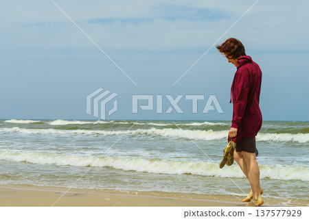 Woman walking on beach Woman walking on beach 137577929