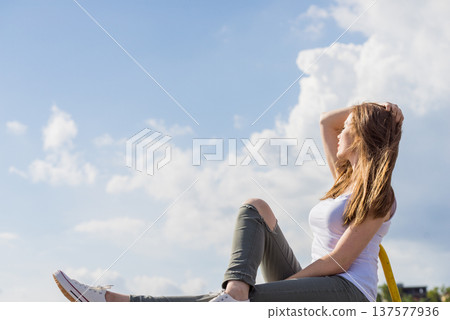 Girl wearing trousers and sneakers relax outdoor Girl wearing trousers and sneakers relax outdoor 137577936