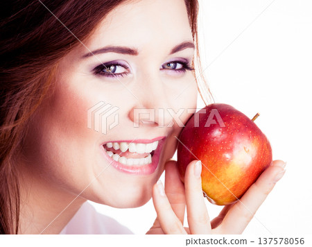 Woman holds apple fruit close to face, isolated Woman holds apple fruit close to face, isolated 137578056