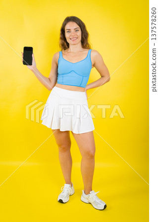 Smiling woman holding smartphone with blank screen for app 137578260