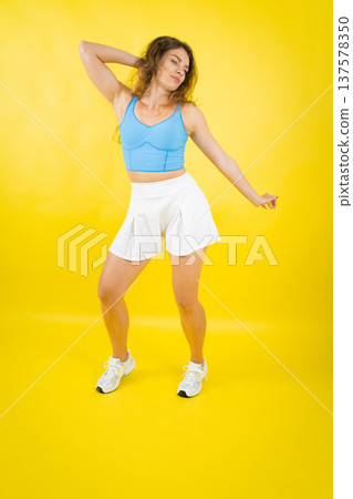 Young woman dancing, expressing freedom and active lifestyle Young woman dancing, expressing freedom and active lifestyle 137578350