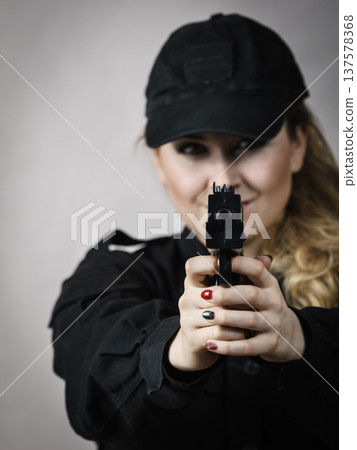 Woman holds gun in hands. 137578368