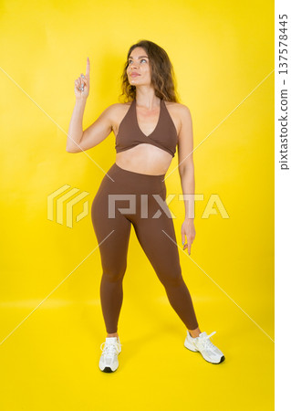 Woman in activewear pointing finger up for direction 137578445