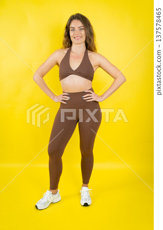 Young woman confidently posing in brown activewear Young woman confidently posing in brown activewear 137578465