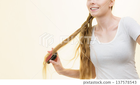 Blonde girl brushing her long hair 137578543