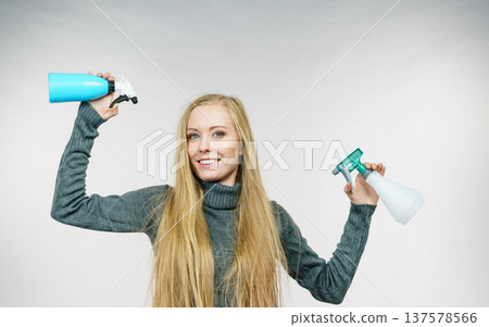 Female messy long hair holds spray bottle 137578566