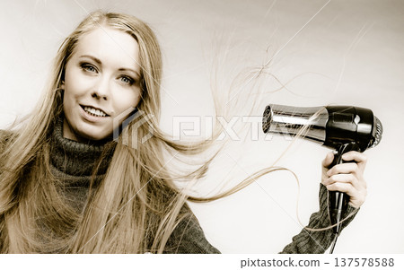 Girl styling her long hair Girl styling her long hair 137578588