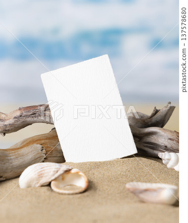 Mockup of blank card on beige sand with seashells, template for beach wedding and event graphics 137578680