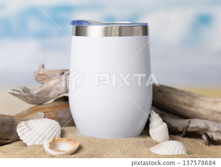 Wine tumbler mockup with blank white 12oz stainless steel cup on sand with seashells and driftwood Wine tumbler mockup with blank white 12oz stainless steel cup on sand with seashells and driftwood 137578684