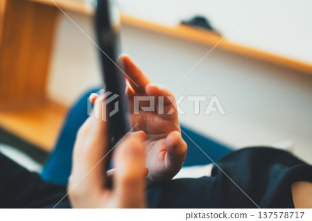 A woman playing with a smartphone A woman playing with a smartphone 137578717