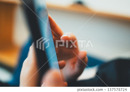 A woman playing with a smartphone A woman playing with a smartphone 137578724