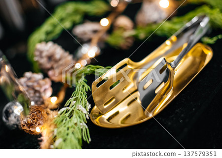 Golden serving tongs for festive holiday catering Golden serving tongs for festive holiday catering 137579351