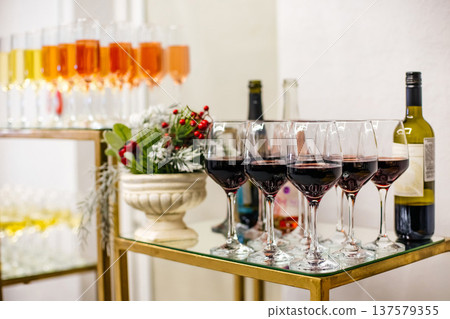 Serving red wine glasses at festive reception party Serving red wine glasses at festive reception party 137579355