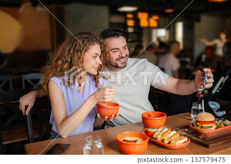 Young couple taking selfie while having lunch at restaurant 137579475