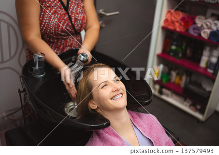 Woman getting hair washed at salon for beauty service 137579493