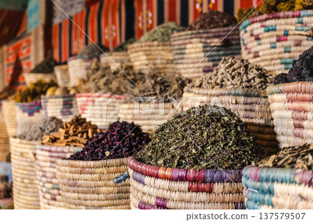 Dried herbal tea leaves hibiscus and spices in traditional woven baskets at colorful Egyptian bazaar Dried herbal tea leaves hibiscus and spices in traditional woven baskets at colorful Egyptian bazaar 137579507