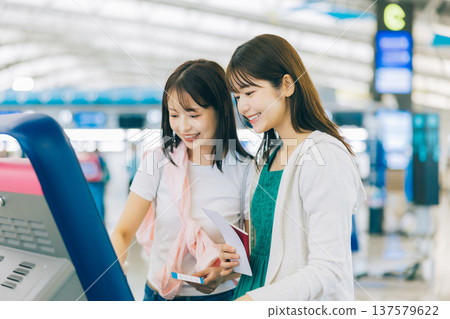 兩名女子獨自在機場辦理登機手續。 (圖片由關西國際機場(KIX)提供) 兩名女子獨自在機場辦理登機手續。 (圖片由關西國際機場(KIX)提供) 137579622