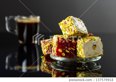 Turkish delights and black coffee on a black reflective background. Turkish delights and black coffee on a black reflective background. 137579918