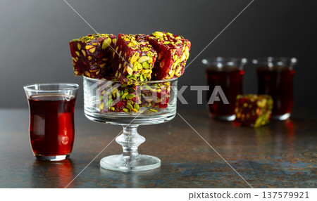 Turkish delights with black tea on a dark background. Turkish delights with black tea on a dark background. 137579921
