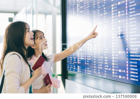 兩名女子正在觀看機場的電子顯示器。 （圖片由關西國際機場（KIX）提供） 137580008