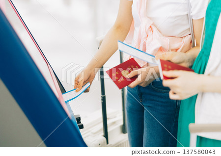 The hands of two women checking in at the airport. (Photo courtesy of Kansai International Airport (KIX)) 137580043