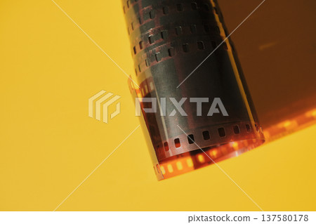 Film negative strip laying on vibrant yellow surface Film negative strip laying on vibrant yellow surface 137580178