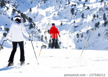 Skiers enjoying snowy mountain slopes on a sunny winter day Skiers enjoying snowy mountain slopes on a sunny winter day 137580212