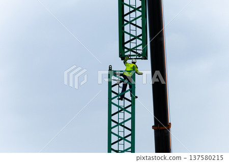 Construction worker on crane tower performing high risk job task Construction worker on crane tower performing high risk job task 137580215
