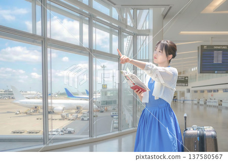一名女旅客在機場查詢出發資訊。 一名女旅客在機場查詢出發資訊。 137580567