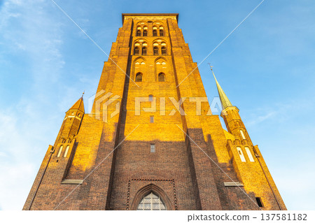 St. Mary's Church in Gdansk, a city on the Baltic coast of northern Poland, Europe. Towering brick architecture reaches for the heavens against a clear blue sky. St. Mary's Church in Gdansk, a city on the Baltic coast of northern Poland, Europe. Towering brick architecture reaches for the heavens against a clear blue sky. 137581182