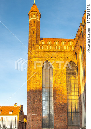 St. Mary's Church in Gdansk, a city on the Baltic coast of northern Poland, Europe. Architectural marvel: Towering brick building with intricate windows against a blue sky. 137581198