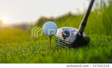 Golf clubs and balls on a green lawn in a beautiful golf course with morning sunshine. Golf clubs and balls on a green lawn in a beautiful golf course with morning sunshine. 137581229