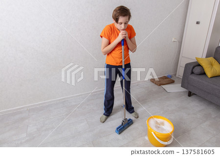 Young person cleaning a room while preparing to mop the floor 137581605