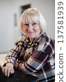 Senior woman working on laptop in cozy indoor space during daytime 137581939