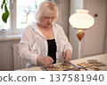 Senior woman engages in creative activity of designing wooden patterns in a bright indoor environment during the afternoon 137581940