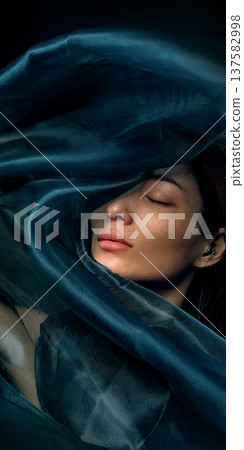 Beauty portrait of Asian woman wrapped in dark teal silk fabric 137582998