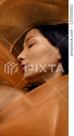 Elegant beauty portrait of Korean woman surrounded by flowing golden silk fabric 137583002