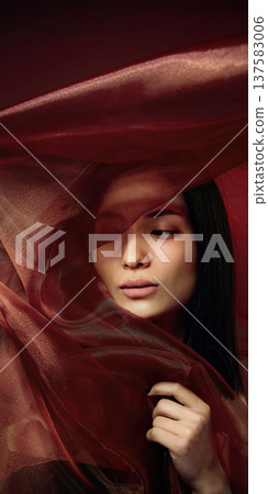 Elegant beauty portrait of Asian woman wrapped in flowing red silk fabric with dramatic lighting Elegant beauty portrait of Asian woman wrapped in flowing red silk fabric with dramatic lighting 137583006