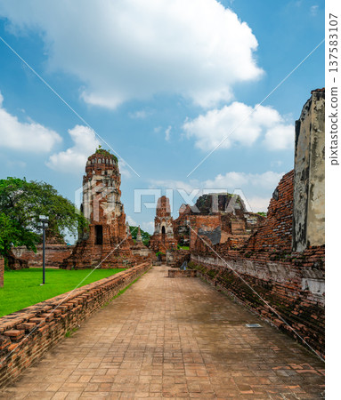Ancient stupa towers in Ayutthaya historical park, Thailand. Ruins of former Siam capital under blue sky on sunny day. Famous travel destination with cultural heritage and Buddhist history. Ancient stupa towers in Ayutthaya historical park, Thailand. Ruins of former Siam capital under blue sky on sunny day. Famous travel destination with cultural heritage and Buddhist history. 137583107