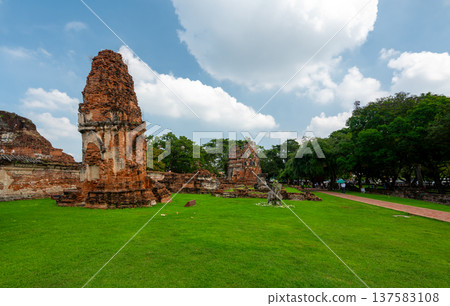 Ancient stupa towers in Ayutthaya historical park, Thailand. Ruins of former Siam capital under blue sky on sunny day. Famous travel destination with cultural heritage and Buddhist history. Ancient stupa towers in Ayutthaya historical park, Thailand. Ruins of former Siam capital under blue sky on sunny day. Famous travel destination with cultural heritage and Buddhist history. 137583108