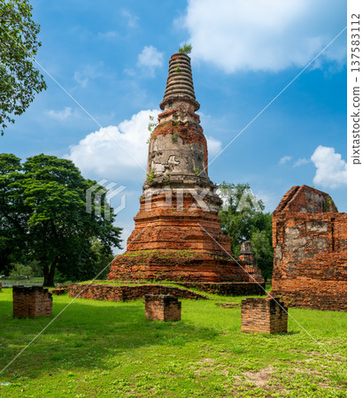Ancient stupa towers in Ayutthaya historical park, Thailand. Ruins of former Siam capital under blue sky on sunny day. Famous travel destination with cultural heritage and Buddhist history. Ancient stupa towers in Ayutthaya historical park, Thailand. Ruins of former Siam capital under blue sky on sunny day. Famous travel destination with cultural heritage and Buddhist history. 137583112