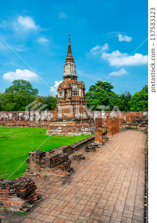 Ancient stupa towers in Ayutthaya historical park, Thailand. Ruins of former Siam capital under blue sky on sunny day. Famous travel destination with cultural heritage and Buddhist history. Ancient stupa towers in Ayutthaya historical park, Thailand. Ruins of former Siam capital under blue sky on sunny day. Famous travel destination with cultural heritage and Buddhist history. 137583123