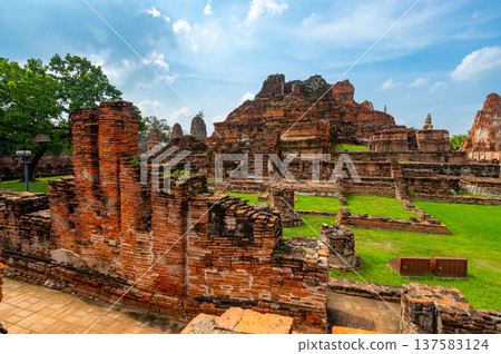 Ancient stupa towers in Ayutthaya historical park, Thailand. Ruins of former Siam capital under blue sky on sunny day. Famous travel destination with cultural heritage and Buddhist history. 137583124