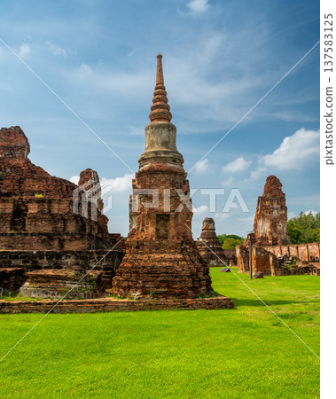 Ancient stupa towers in Ayutthaya historical park, Thailand. Ruins of former Siam capital under blue sky on sunny day. Famous travel destination with cultural heritage and Buddhist history. Ancient stupa towers in Ayutthaya historical park, Thailand. Ruins of former Siam capital under blue sky on sunny day. Famous travel destination with cultural heritage and Buddhist history. 137583125