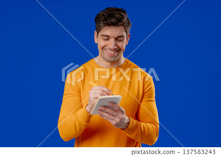 Handsome Young Man Writing Notes Planner, Pen. Student Writes Plans, To-Do List Handsome Young Man Writing Notes Planner, Pen. Student Writes Plans, To-Do List 137583243