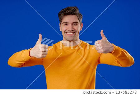 Handsome Man With Hand Sign Like, Thumbs Up Gesture.happy Guy On Blue Studio 137583278