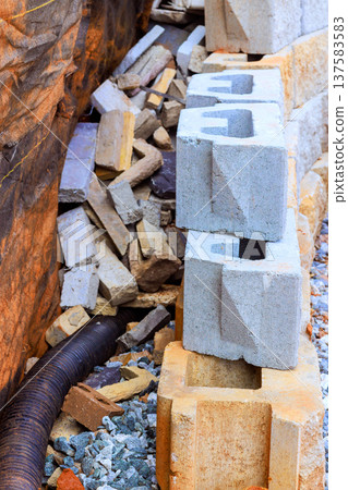 Construction site stacked concrete blocks with scattered materials on drain pipe 137583583