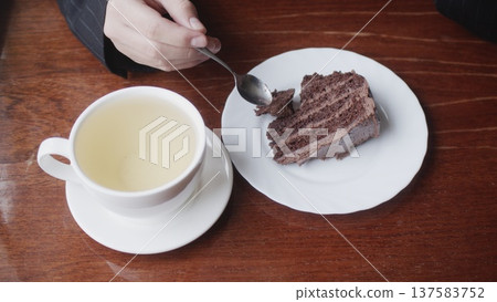 A white cup and cake on a plate. View from above. A white cup and cake on a plate. View from above. 137583752