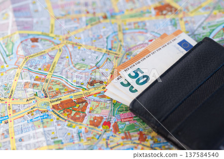 Euro banknotes in a black leather wallet placed on a detailed city map of Berlin, Germany. Euro banknotes in a black leather wallet placed on a detailed city map of Berlin, Germany. 137584540